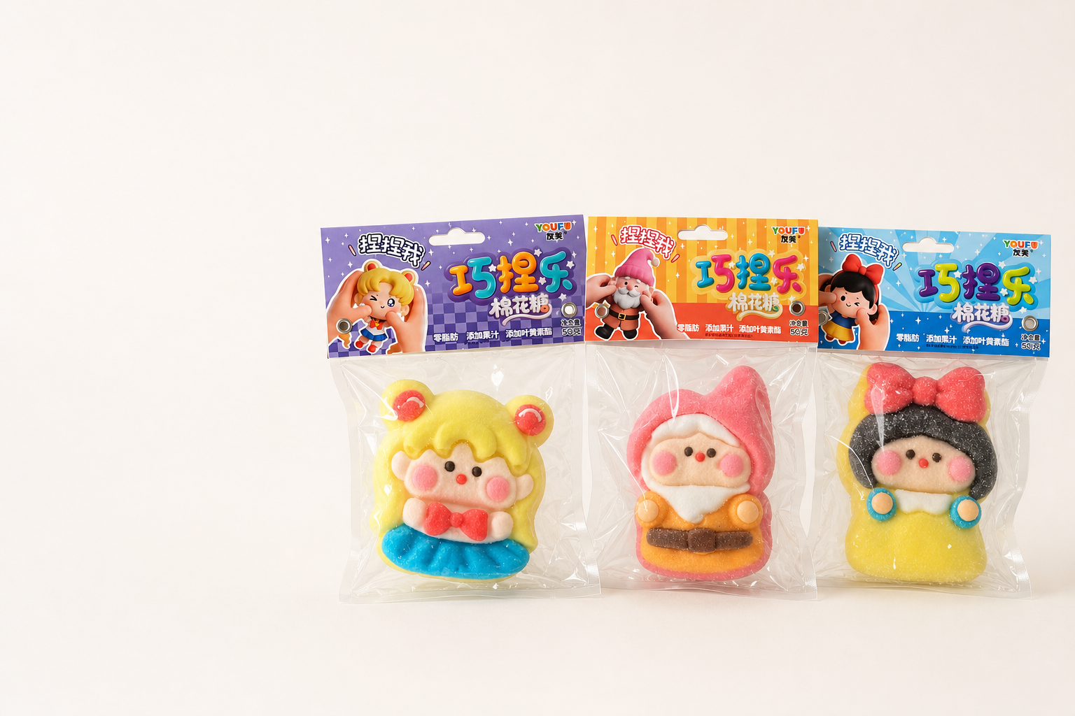 Three colorful character-shaped marshmallow candies in purple, orange, and blue retail packaging